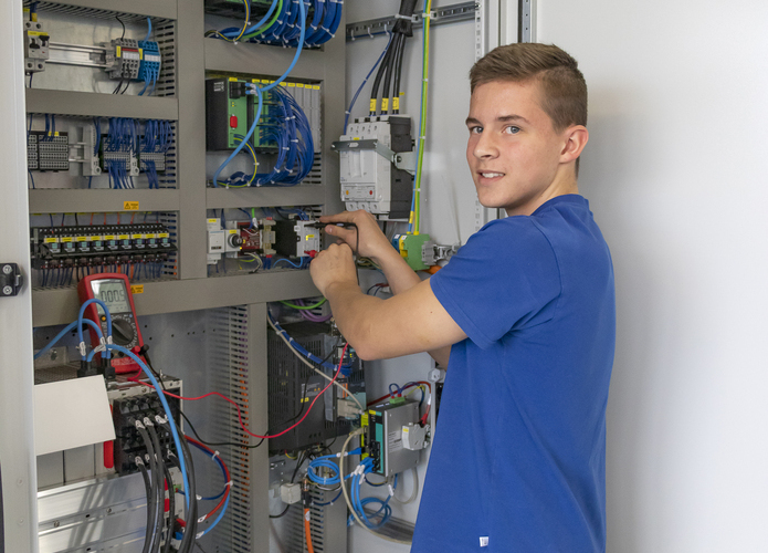 Apprenti travaillant sur l'armoire électrique | © Reiden Technik AG